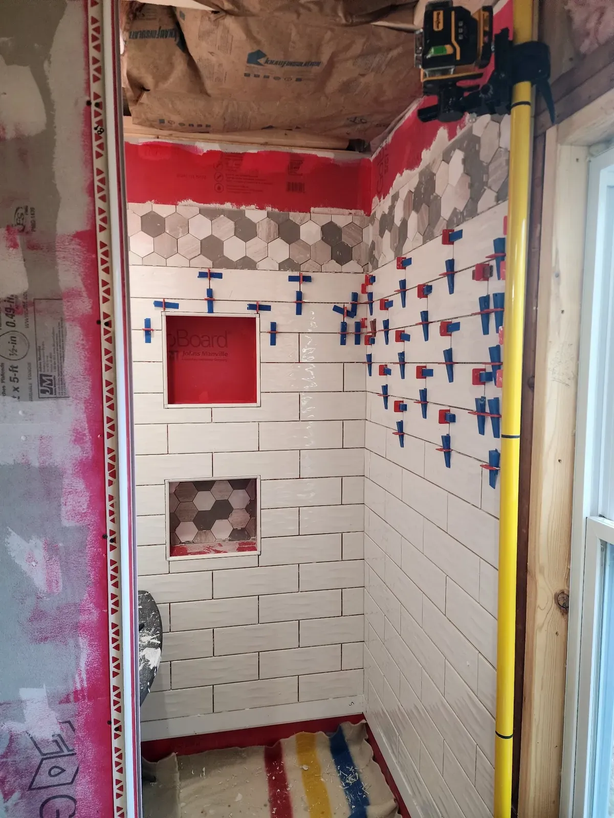 Shower wall tile installation during the cabin remodel