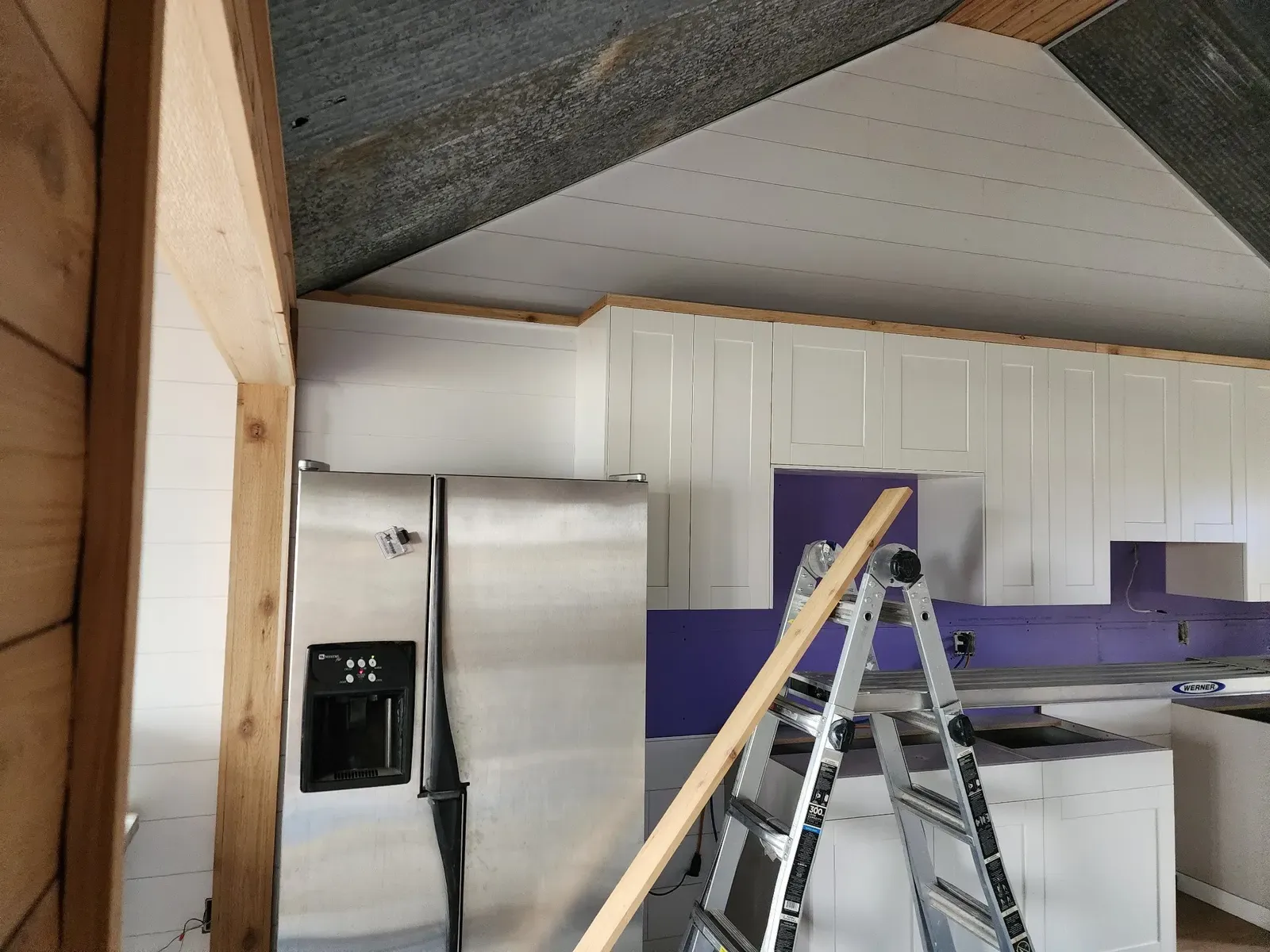 Cabin kitchen cabinets, island, and refrigerator during installation