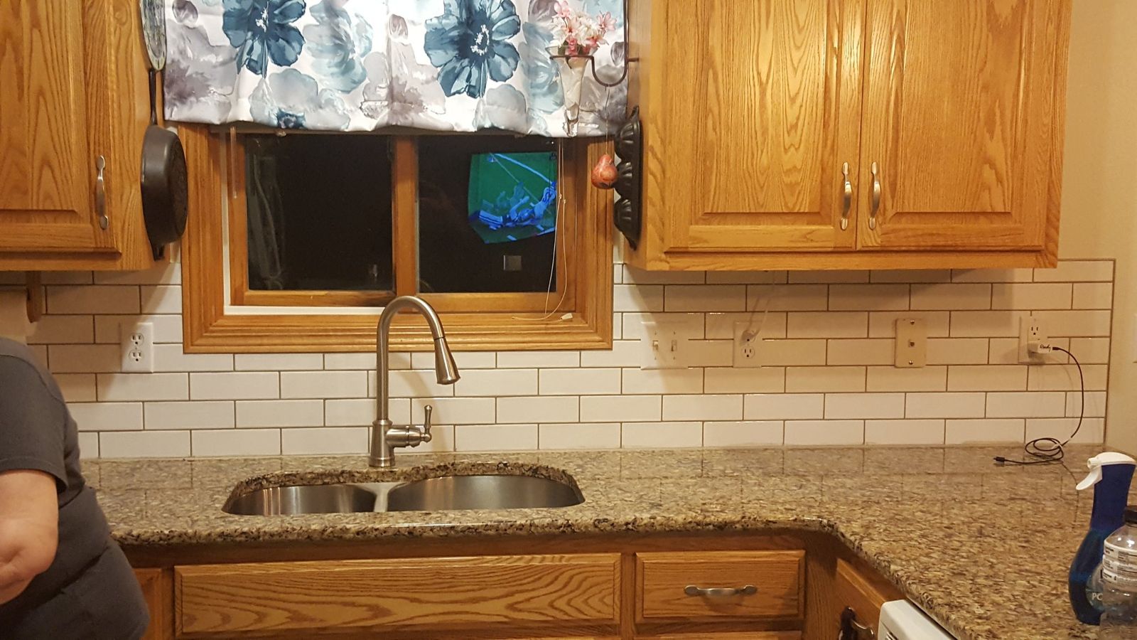White subway tile backsplash and updated faucet behind the kitchen sink