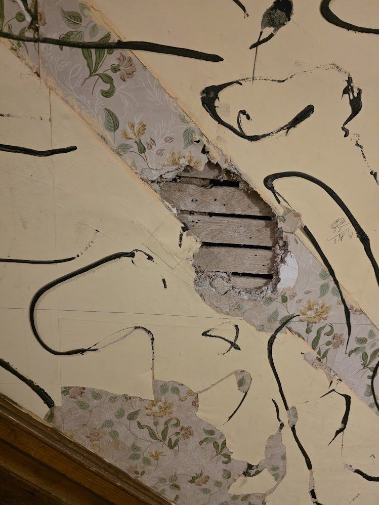 Damaged interior wall opened down to the wood lath
