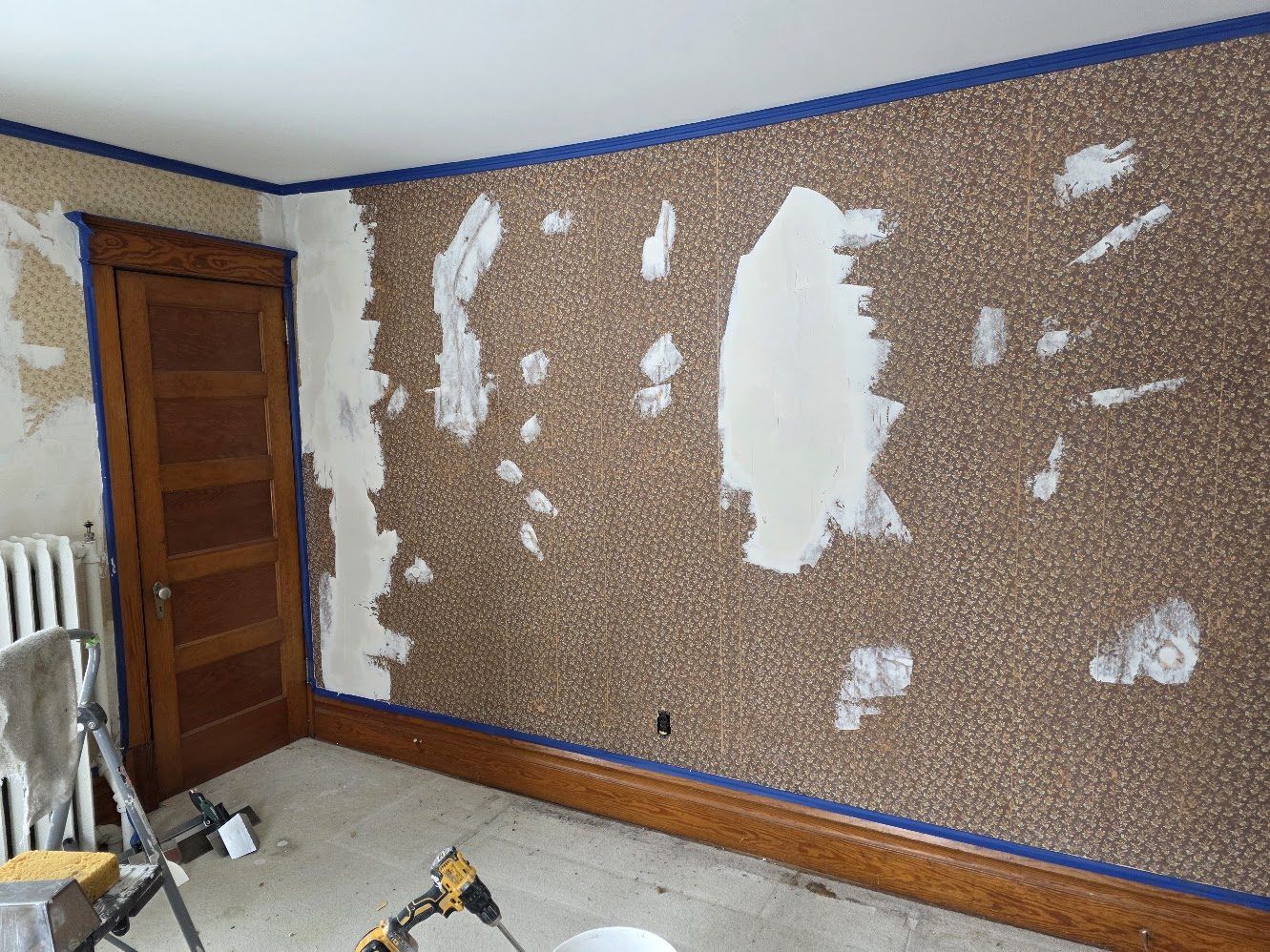 Interior wall being skim-coated and patched