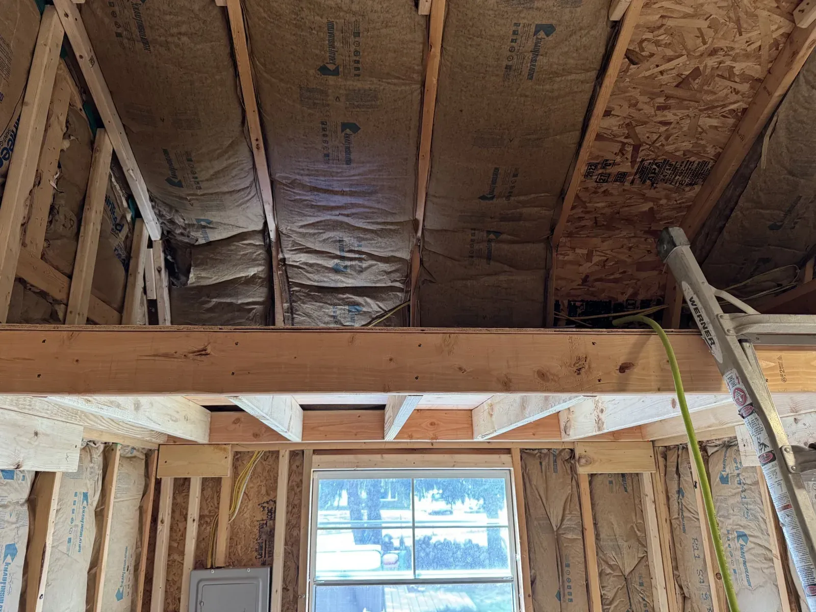 Ceiling insulation and the main beam above the framed window wall