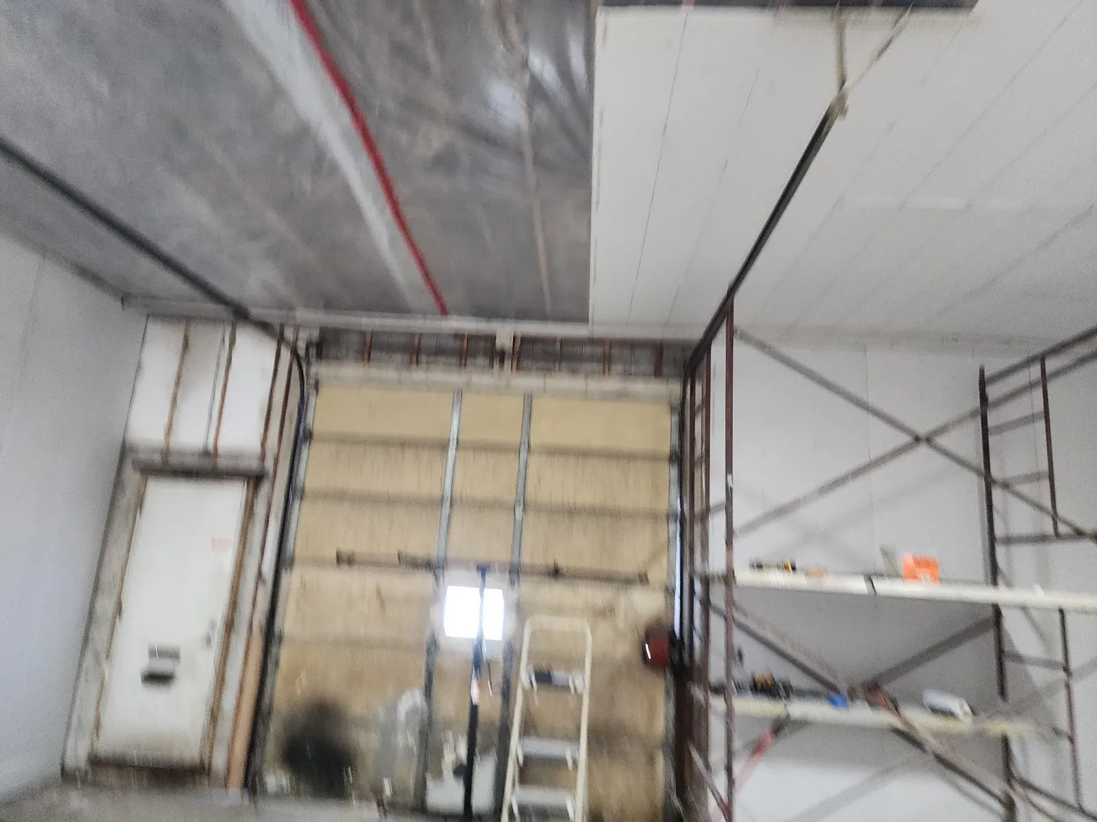 Ceiling work under way with protective plastic in the former garage