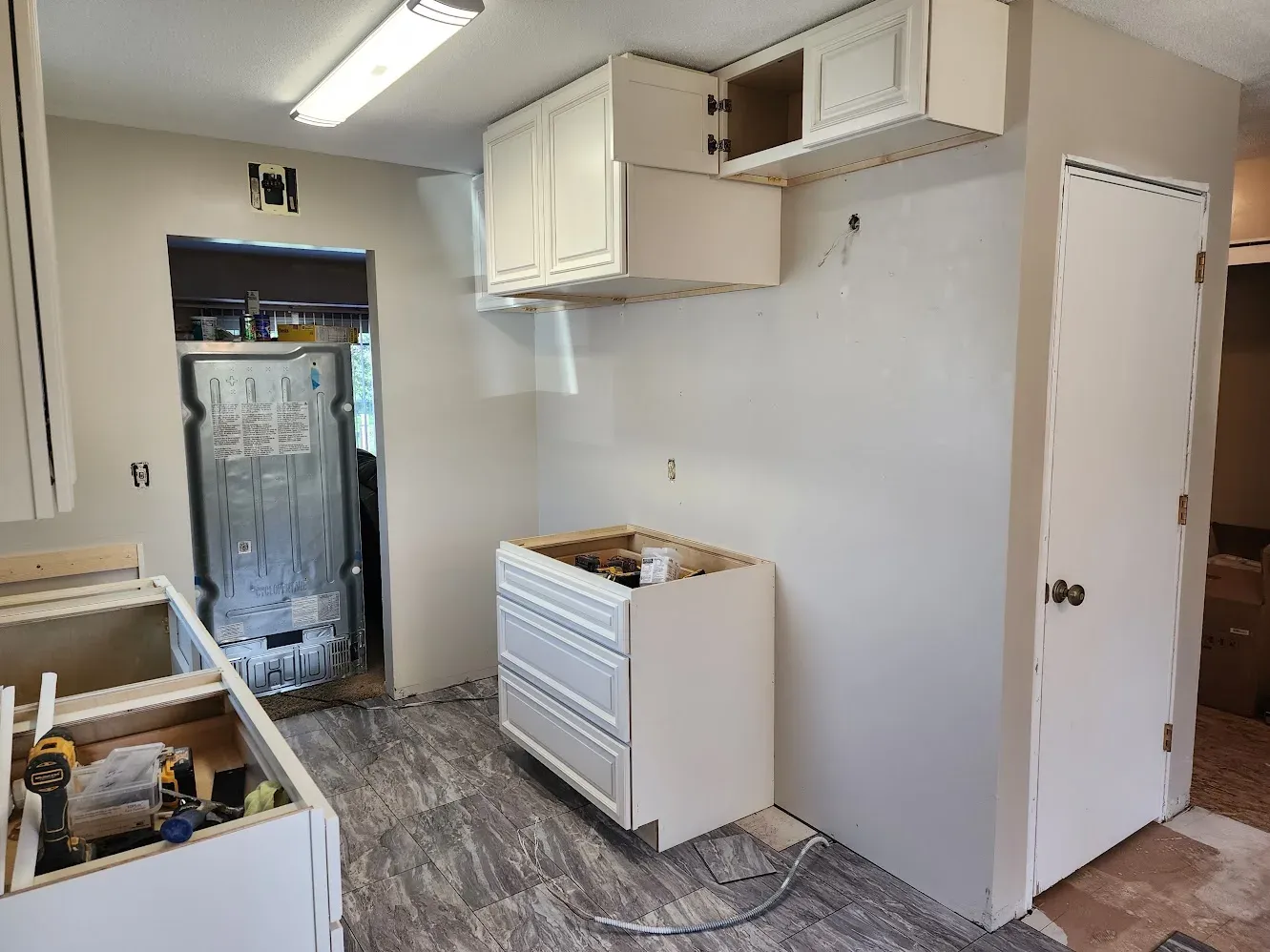 New light-colored kitchen cabinets being installed