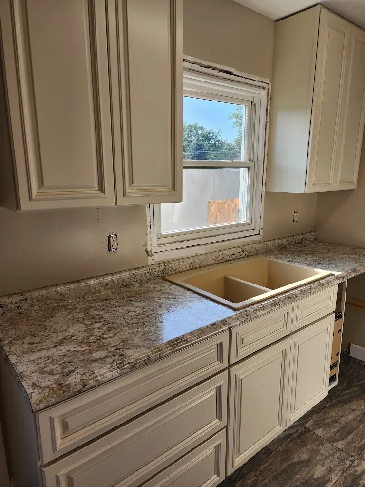 Finished light-colored kitchen cabinets and new counters