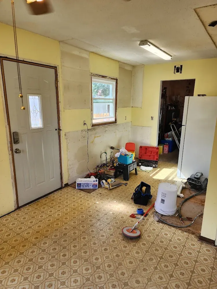 Old kitchen cleared out after cabinet removal during demolition