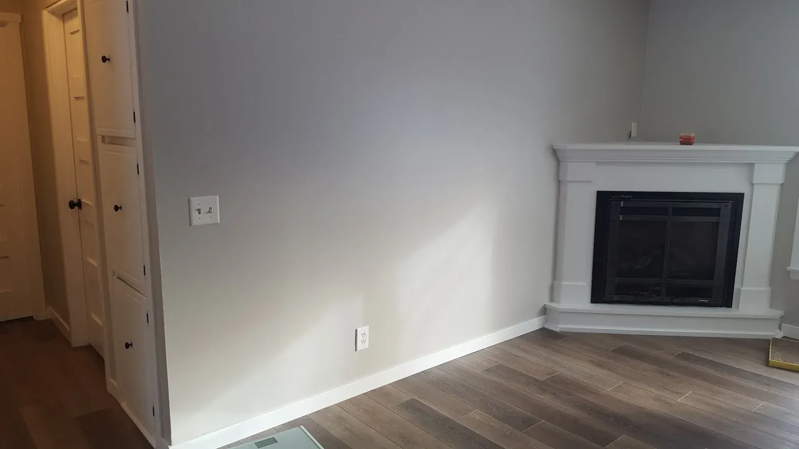 Refinished living room with updated floors, walls, windows, and fireplace