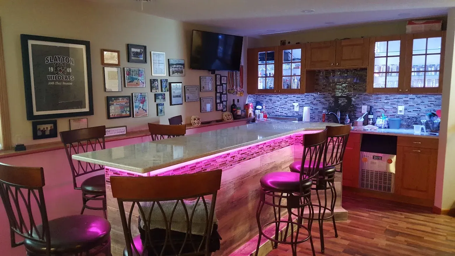 Finished basement wet bar with cabinets, sink, and tile backsplash