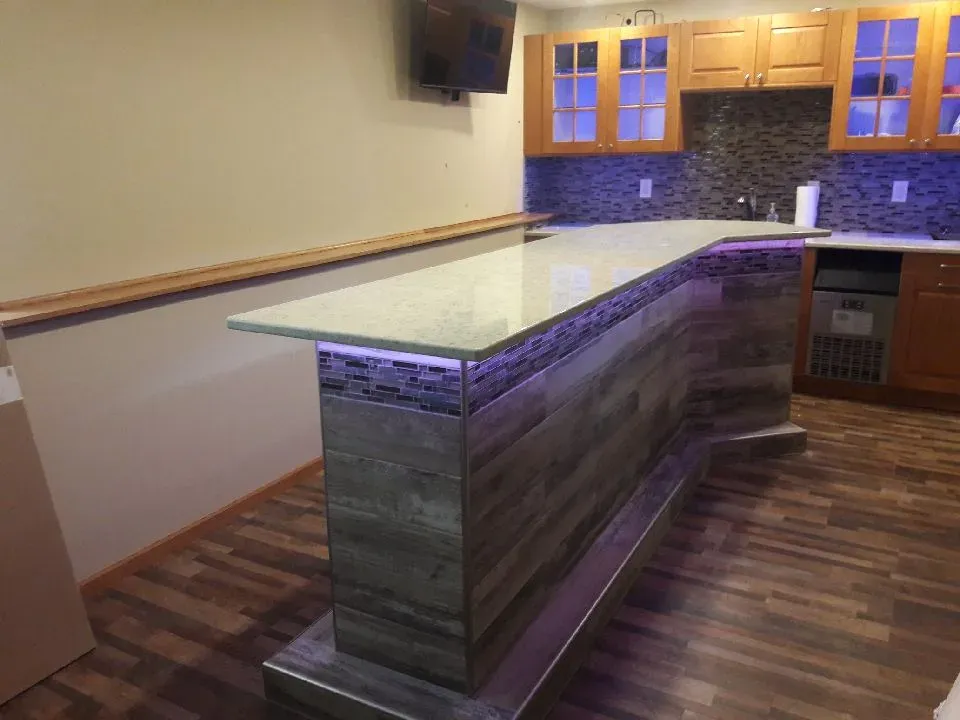 Finished custom basement bar with mosaic tile surround and counter