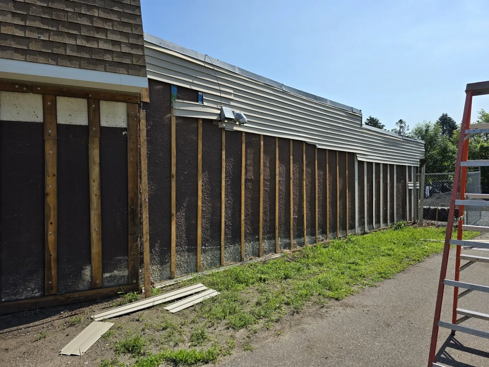 Long exterior wall stripped to the studs for new siding
