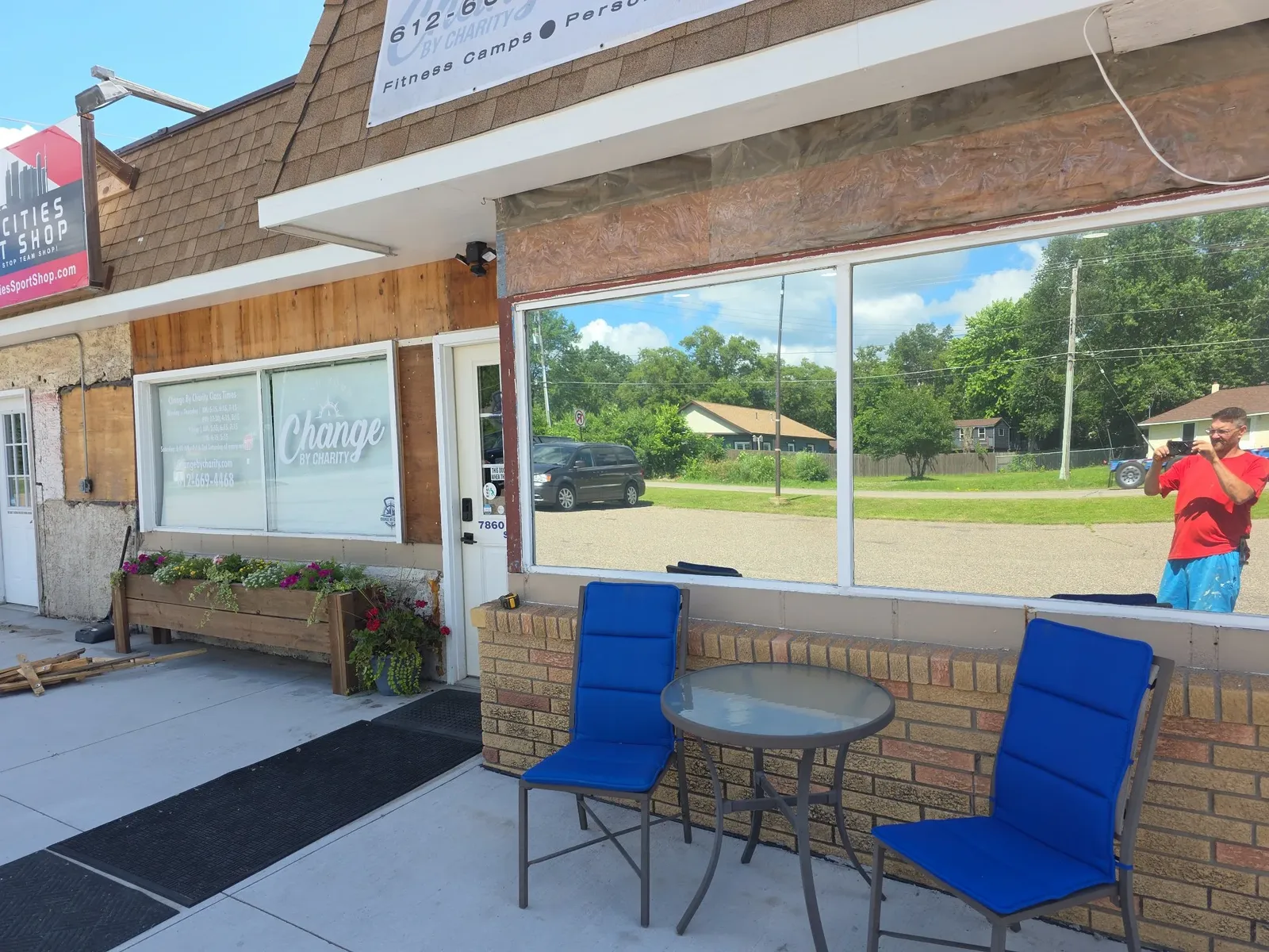 Storefront cladding and trim in progress with outdoor chairs set aside