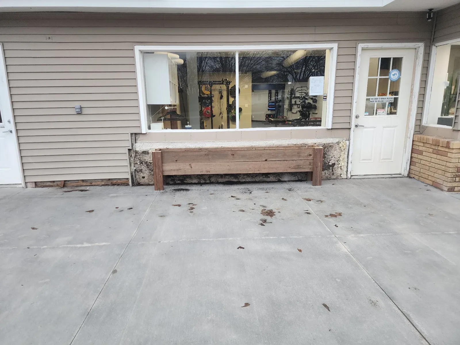 Finished performance center siding with a wooden planter box below the storefront window