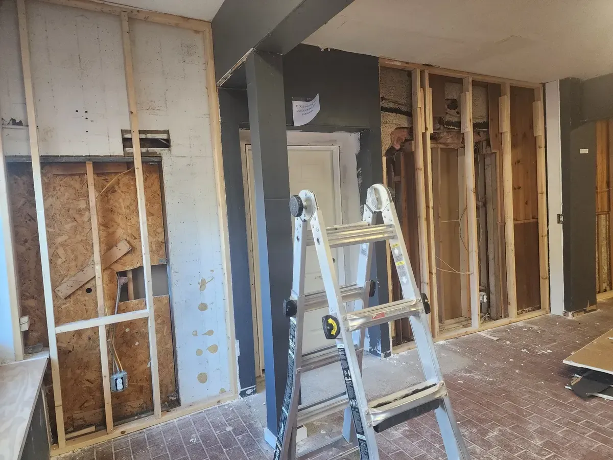 Wood framing under construction with a step ladder in a commercial gym build-out
