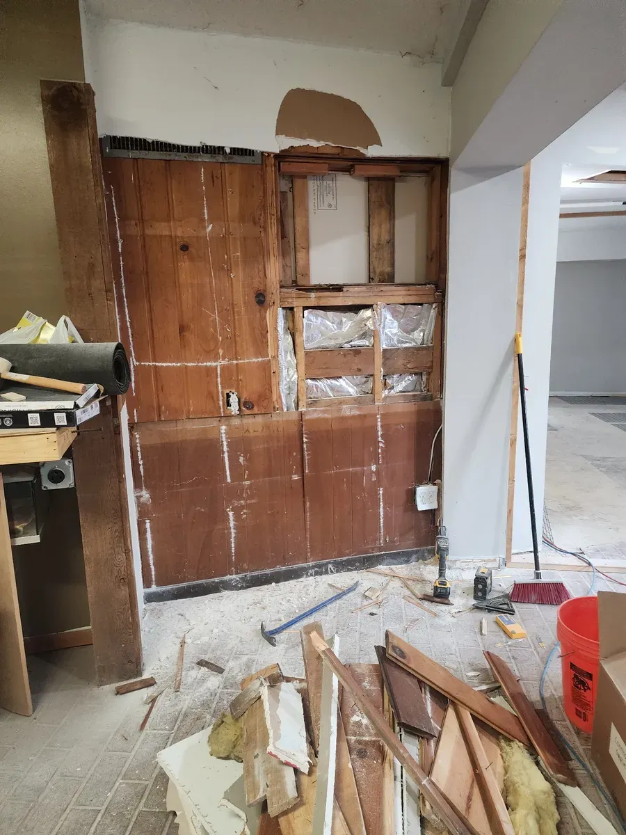 Wall paneling being torn out during demolition of the commercial gym
