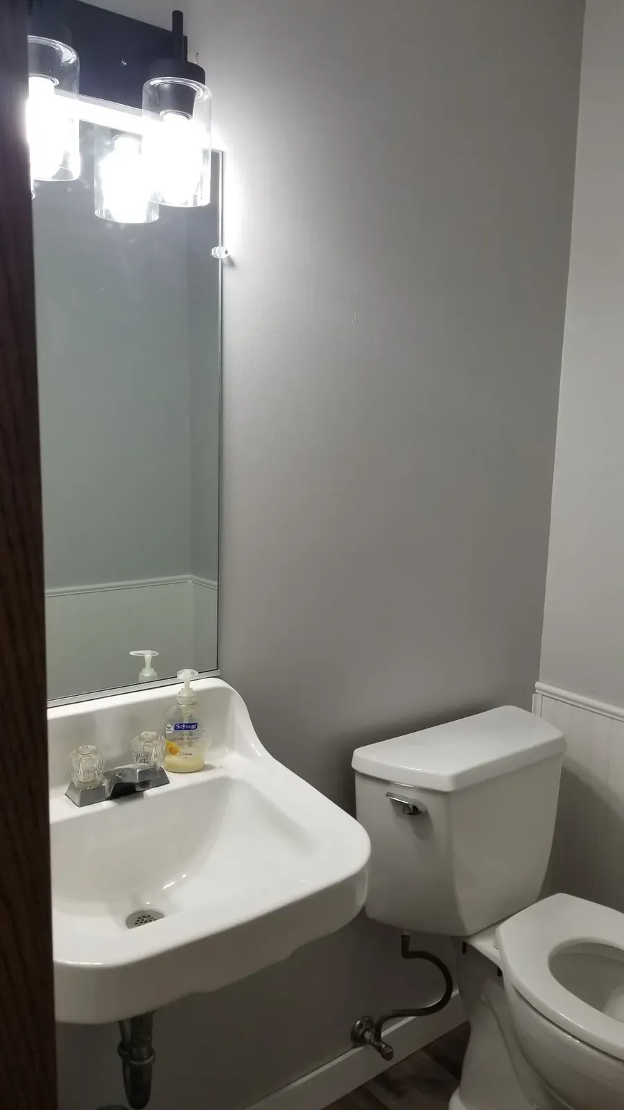 Finished powder room sink and mirror above beadboard wainscoting